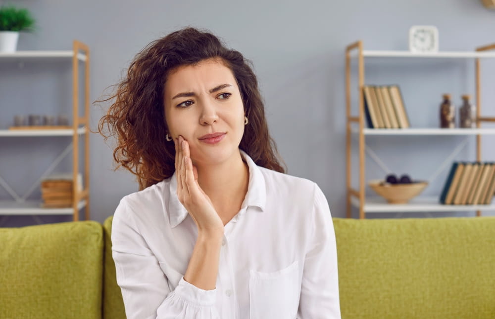 Beautiful young woman feeling toothache having dental problem.