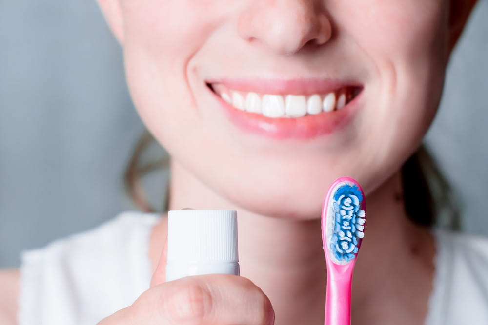 Dental hygiene and care. White toothbrush. Young healthy woman face with beauty smile