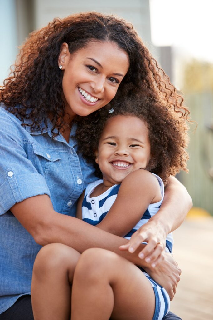 mother and young daughter smile