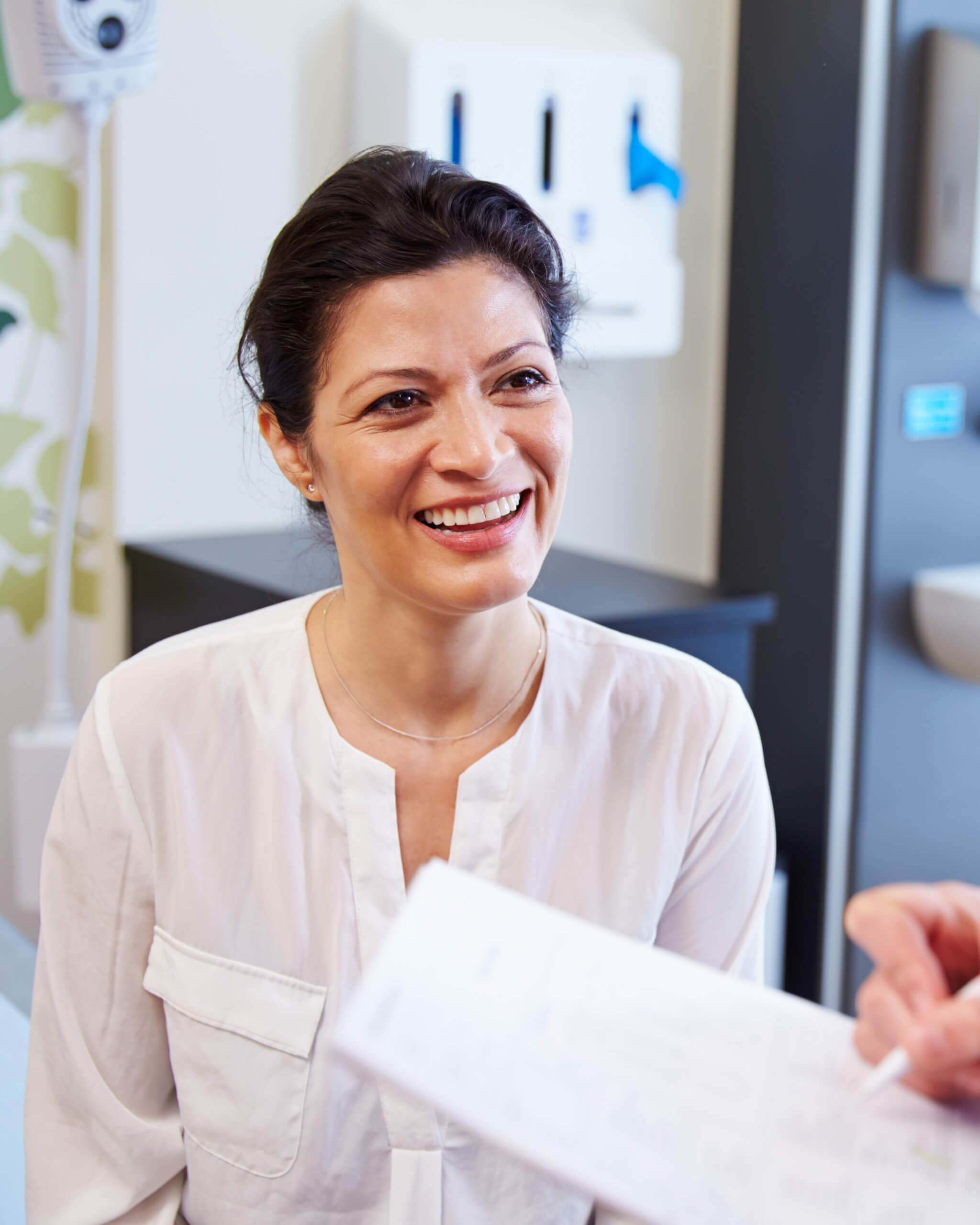 Female Patient And Doctor Have Consultation In Hospital Room