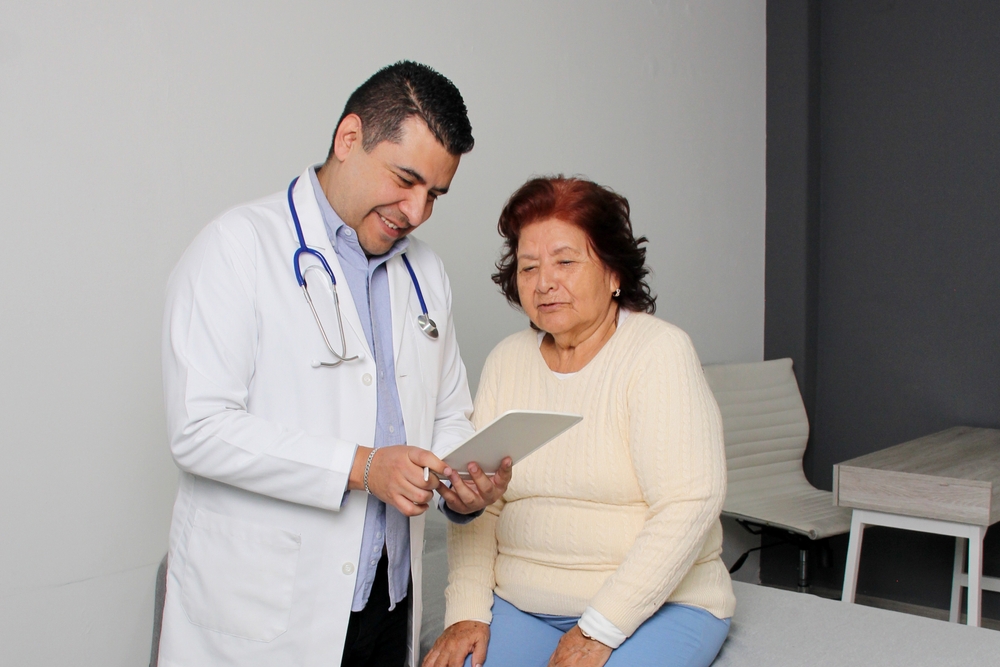 Elderly 80-year-old Latin woman visits the dark-skinned geriatric specialist medical doctor to check her health