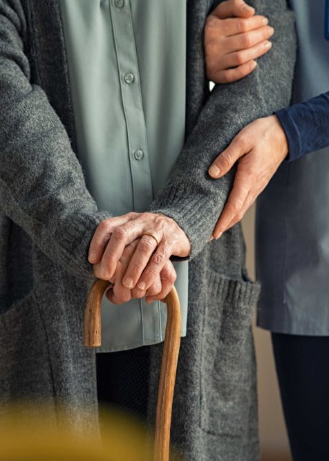 Young caregiver helping senior woman walking