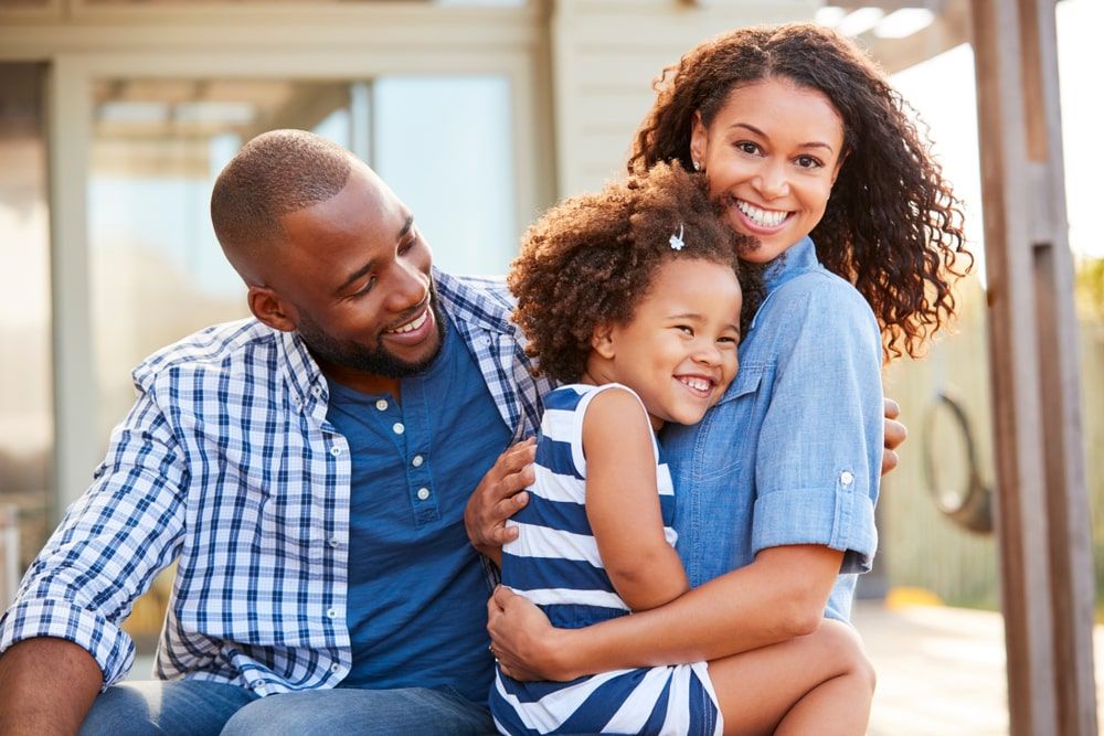 Family embracing outdoors smiling